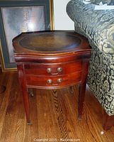 Front side view of the antique occasional table showing drawer fronts and legs