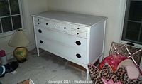 Full view of antique white painted distressed dresser showing three large drawers and smaller jewelry drawers on top row.