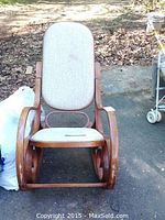 Front view of wooden bentwood rocking chair with upholstered seat and back