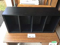 Front view of black wooden CD holder rack with vertical slots for holding CDs upright.