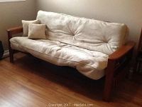 Front view of assembled futon sofa bed with two throw pillows