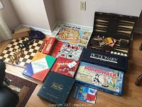 Wide view of the collection of board games showing various boxed games and game boards including chess and backgammon sets.