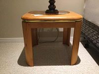 Side view of one oak veneer side table showing the legs and top with rounded edges and medium oak finish
