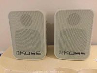 Front view of the pair of white KOSS speakers showing mesh grille and logo.