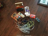 Overview photo showing all electronics and cables including Sony headphones, Pop Phone adapter, folding opera glasses and assorted wires
