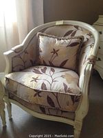 Front view of chair showing curved wood frame and upholstered seat and back