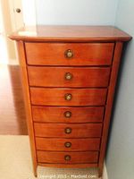 Front view showing seven drawers with brass-tone ring pull handles