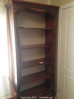 Full view of bookcase showing five shelves and carved frame