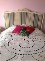 Front view of assembled bed frame and headboard against pink wall