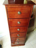 Front view of the wood cabinet showing six drawers with round metal handles.