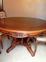 Full view of round wood dining table with pedestal base and chairs