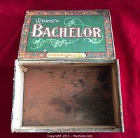 Top open view of the green and red Wilson's Bachelor wooden cigar box showing interior wood stained inside.