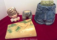 4 vintage ceramic planters and a ceramic girl figurine arranged on a red cloth showing size and details