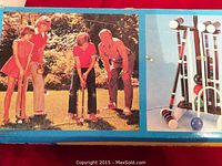 Box showing photo of family playing croquet with mallets and balls visible