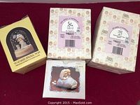 Four boxed Precious Moments figurines, including one flower dome labeled 'To A Very Special Mom' and three boxed figurines from Enesco.