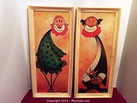 Full view of two framed vintage clown paintings side by side, showing clown characters in color and ornate frames.