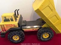 Front and side view of the Tonka Turbo-Diesel dump truck showing cab details, tires, and raised dump bed feature.