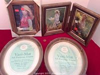 Photo showing two joined rectangular wood-tone frames alongside three oval Vari-Mat frames with tags inside indicating sizes and features.