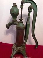 Full side view of the antique hand water pump showing handle and spout with 'SMART' and 'BROCKVILLE ONT' markings.