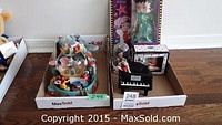 Photo of boxed and individual items including stuffed Dumbo, musical globe with Dumbo, boxed Betty Boop doll in green dress, musical piano figurine with Betty Boop, salt and pepper shakers in box, and Betty Boop under glass dome.