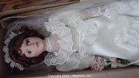 Gibson Wedding Doll Katherine in white satin wedding gown with lace, lying in box showing detailed facial features and floral decoration on dress.