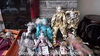Photo of seven Harlequin dolls arranged together showing a variety of costumes and faces.
