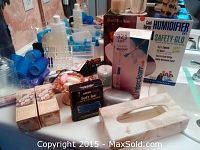 Overview photo showing boxed Sunbeam humidifier, Braun toothbrush, decorative bathroom items, assorted bottles and containers