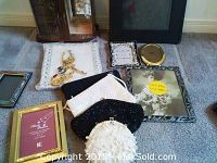 Overview of jewellery pieces, picture frames, and beaded bags spread on floor