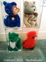 Four Beanie Babies in clear display cases including blue bear, gray bear, green bird, and red bird.