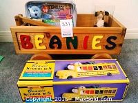 Wooden wagon with 'BEANIES' in colorful letters visible with boxed Beanie Baby school bus stacked beneath it.