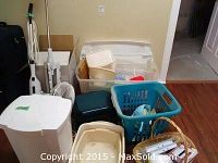 Overview of lot containing vacuum, fan, multiple plastic storage containers, laundry basket tote, and woven basket.