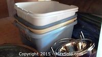Stacked plastic storage bins and stainless steel pet bowl shown