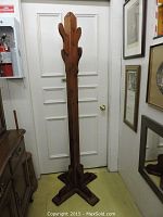 Full front view of the pine wood hall tree showing its tapered tall structure and four wooden hooks on top with the sturdy base.