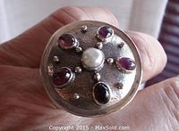 Close-up of ring top showing textured surface, five oval tourmaline cabochons, center pearl and silver bead accents.