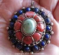 Front view showing central turquoise stone, coral segments, and lapis stones with detailed silver setting