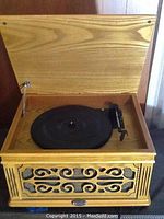 Wooden Crowley record player open showing the turntable and tone arm