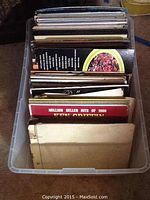 Top view of plastic box filled with assorted vinyl records showing the album cover of Million Seller Hits of 1966 by Ken Griffin