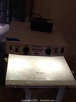 Front view showing the illuminated rectangular reading surface and control panel with zoom, focus knobs, power and mode switches with 