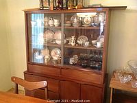 Front view showing two-section hutch with glass doors and lower storage