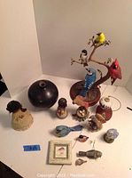 Overall view of Indian vase, assorted decorative bird figurines including small and large birds, bird on branch stand, and framed bird artwork