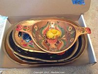 Top view of 7 nested wooden trays painted with traditional Russian floral designs in various colors