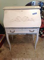 Full front view of the vintage white wooden secretary desk showing decorative scrollwork and curved legs.