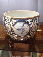 Front view of the blue and white gold-trimmed ceramic bowl showing floral medallion design.