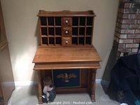 Front view of Hitchcock secretary desk showing drop-front closed and eagle motif panel.