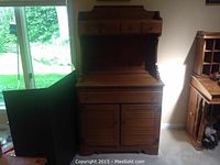 Photo of tall wooden Hitchcock hutch with upper drawers, open shelf, and lower cabinet with louvered doors