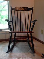 Front view of the Hitchcock Ashley Child's wooden rocker showing black painted finish, spindled back and arms, wooden seat and curved rockers.