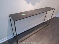 Front view of black metal console table against wall
