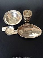 Four sterling silver pieces displayed on black background