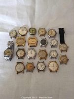 Overview of 20 assorted watches arranged in rows, showing various case shapes and dial colors.