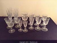 Full view showing all 16 stemware glasses arranged on a black surface.